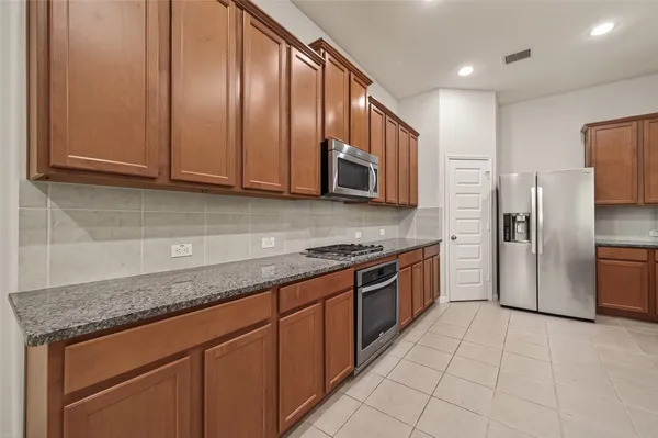 a kitchen with stainless steel appliances granite countertop a sink stove and refrigerator