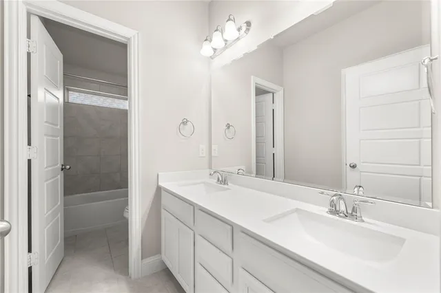 a bathroom with a double vanity sink mirror and shower