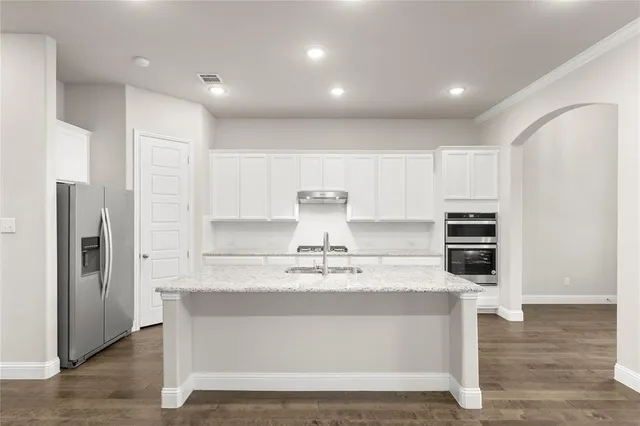 a view of kitchen with stainless steel appliances granite countertop a stove and a refrigerator
