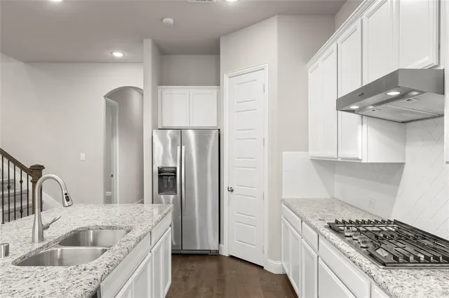 a kitchen with stainless steel appliances granite countertop a sink stove and refrigerator