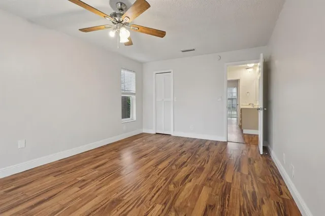 a view of empty room with wooden floor