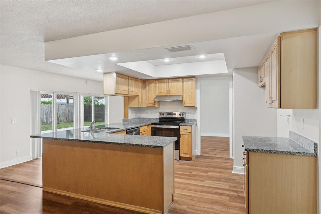 1541 Northwest 9th Street Boca Raton, FL 33486 - Photo 23 of 63 a kitchen with stainless steel appliances granite countertop a stove a sink and a refrigerator