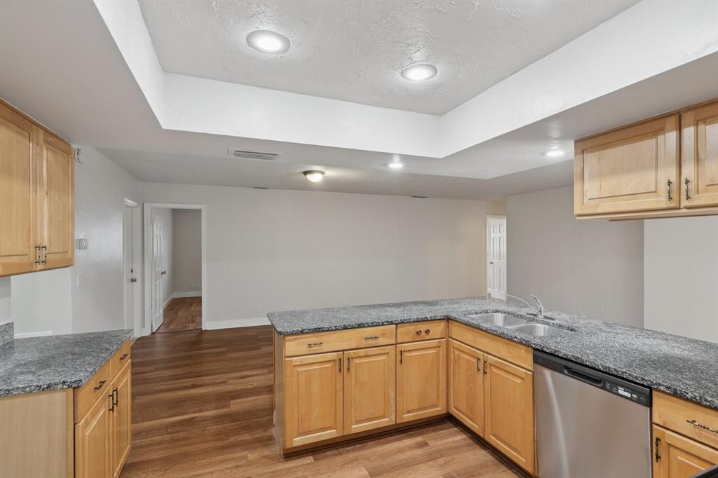 1541 Northwest 9th Street Boca Raton, FL 33486 - Photo 29 of 63 a kitchen with granite countertop a sink and dishwasher cabinets with wooden floor