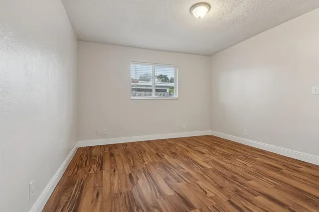 a view of a room with wooden floor and window