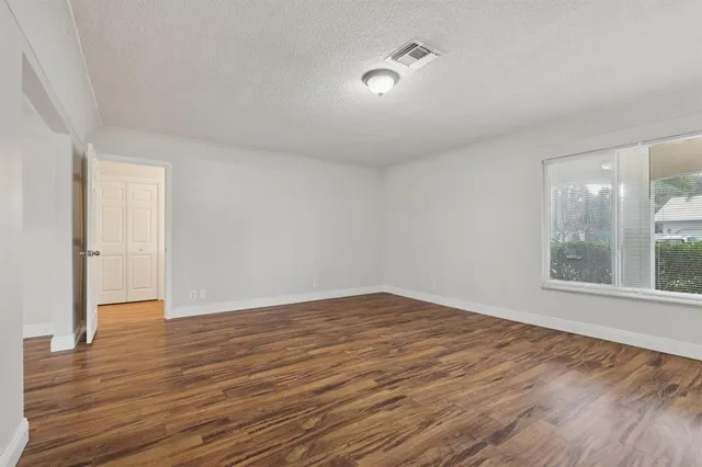 a view of empty room with wooden floor