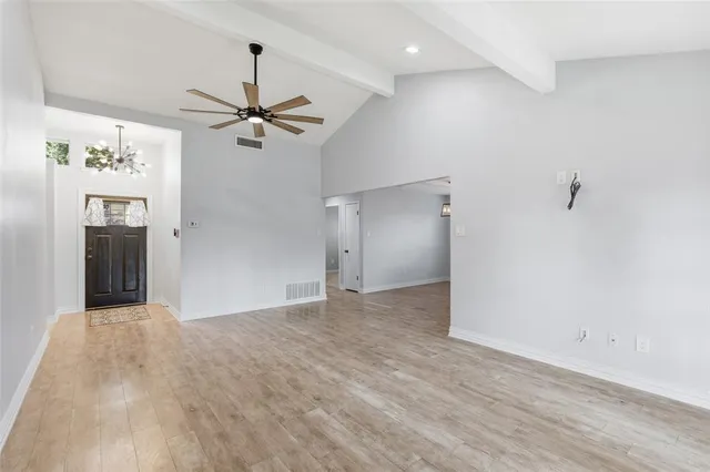 wooden floor in an empty room with a fan