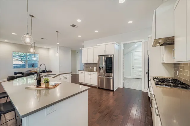 a kitchen with stainless steel appliances a refrigerator sink and microwave