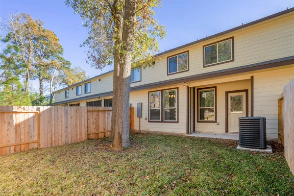 a view of a house with a yard and wooden fence