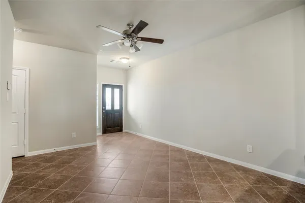 a view of an empty room with a chandelier fan