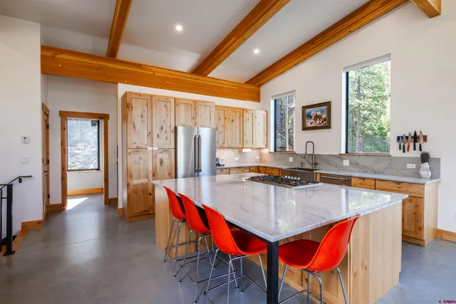 a kitchen with stainless steel appliances granite countertop sink refrigerator and window