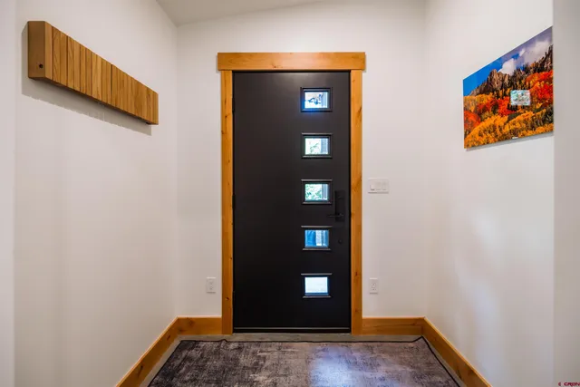 a view of a hallway with wooden floor and closet