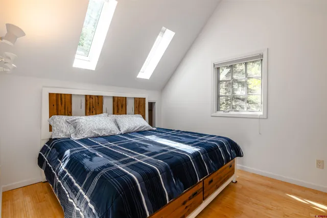 a bed sitting in a bedroom next to a window