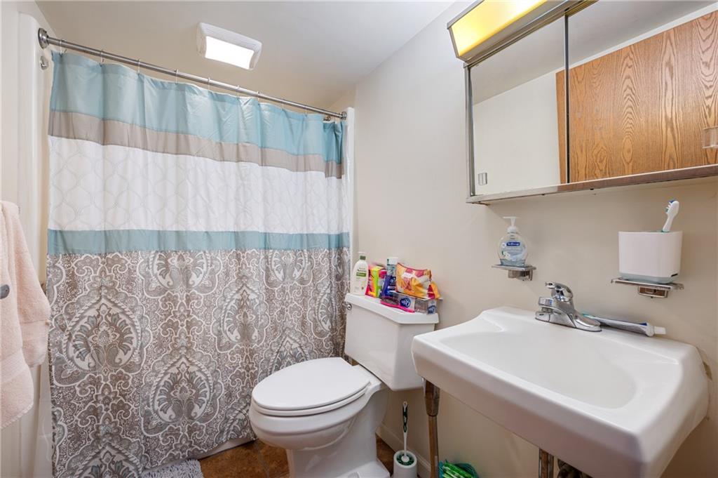 330 46th Street Pittsburgh, PA 15201 - Photo 20 of 25 a bathroom with a sink a toilet and shower curtain