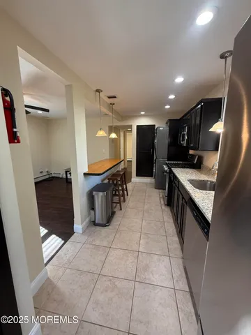 a large white kitchen with stainless steel appliances kitchen island granite countertop a sink and a stove