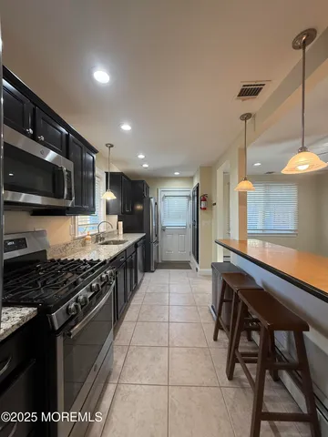a kitchen with stainless steel appliances granite countertop a stove a sink a microwave and a refrigerator
