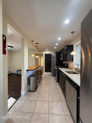 a large kitchen with a large counter top and stainless steel appliances