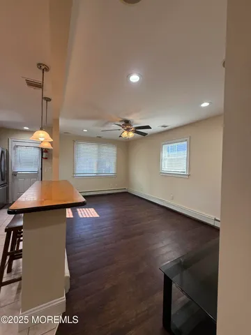 a view of a room with wooden floor table and chairs