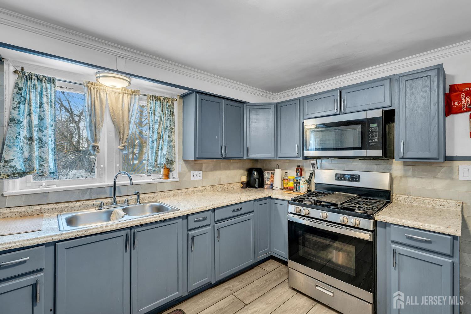 821 Front Street Dunellen, NJ 08812 - Photo 5 of 17 a kitchen with sink a microwave and cabinets