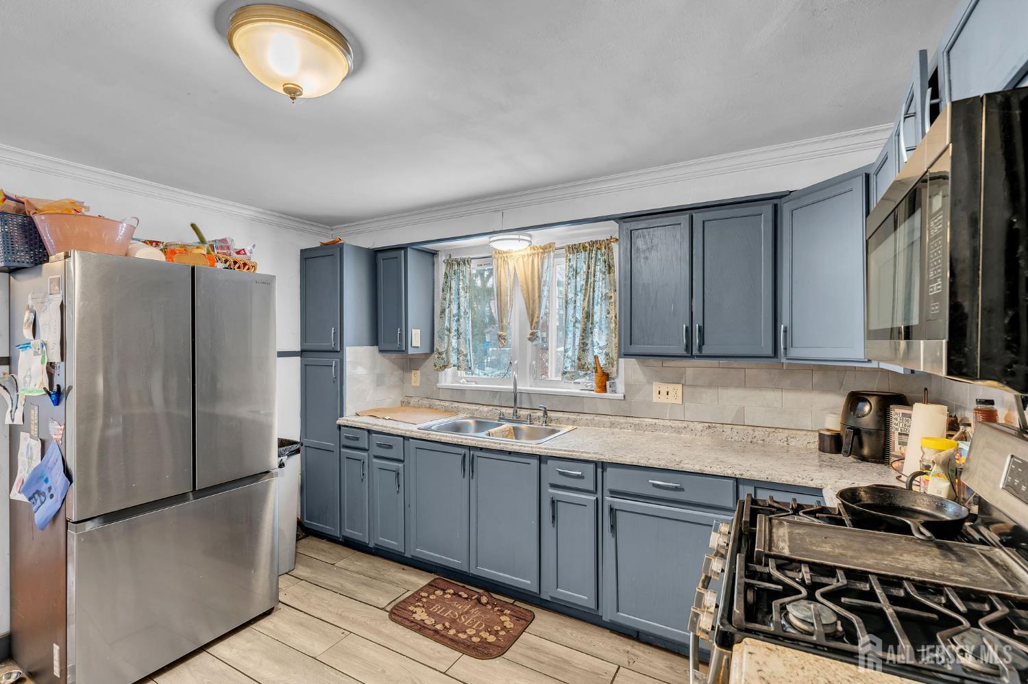 821 Front Street Dunellen, NJ 08812 - Photo 8 of 17 a kitchen with stainless steel appliances granite countertop a sink stove and refrigerator