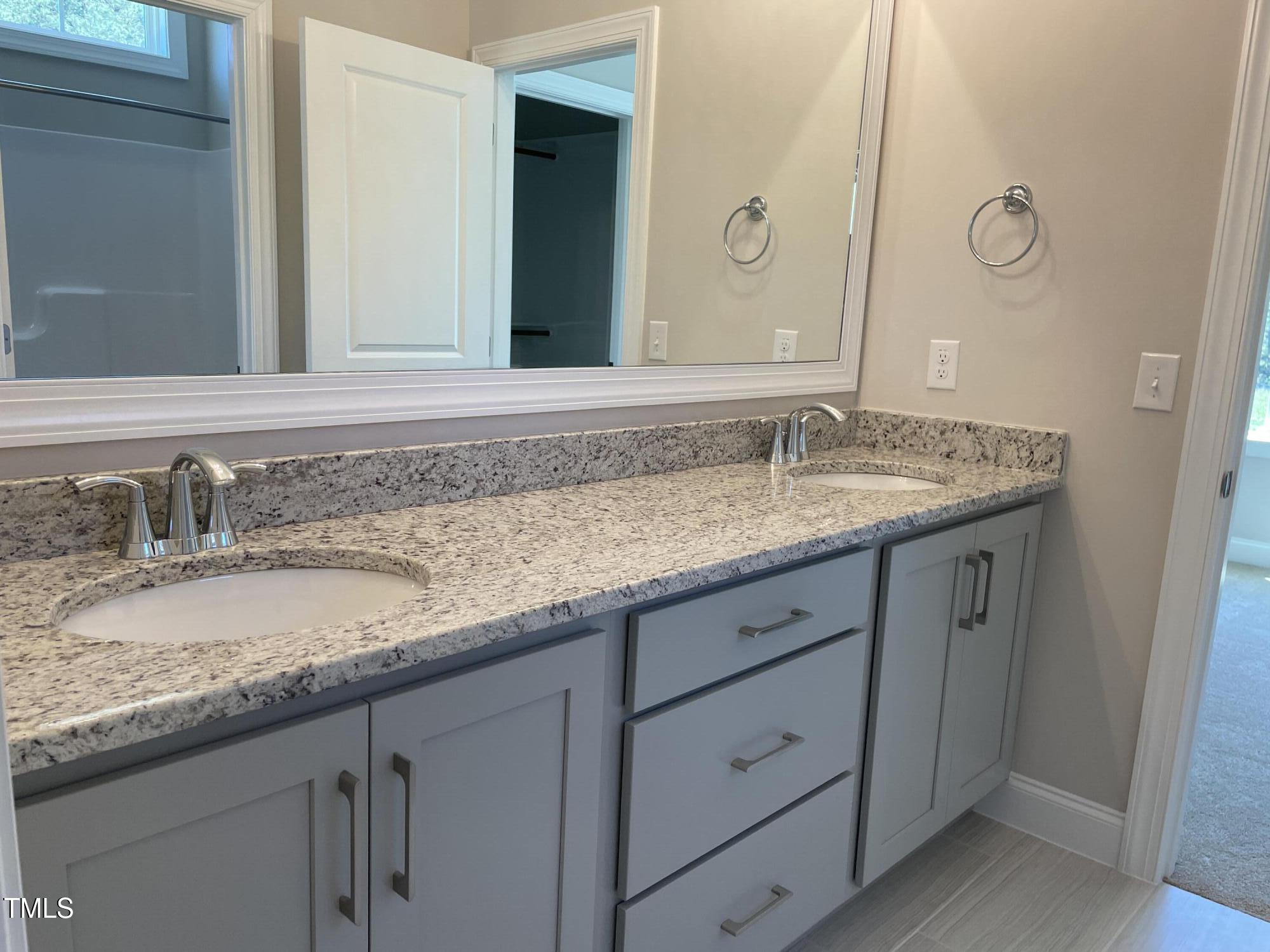 85 Old Gdn Lane Youngsville, NC 27596 - Photo 11 of 17 a bathroom with a granite countertop sink and a mirror