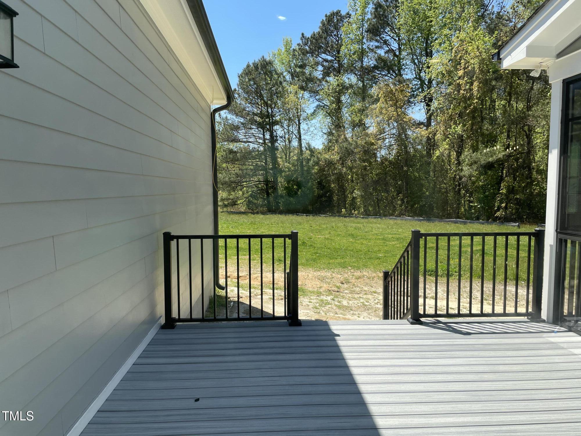 85 Old Gdn Lane Youngsville, NC 27596 - Photo 16 of 17 a view of a deck with wooden floor and fence next to a yard