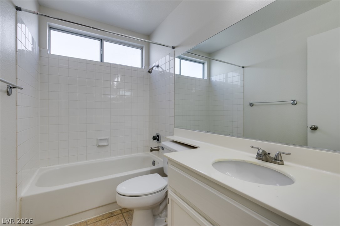 307 Cavalla Street Henderson, NV 89074 - Photo 33 of 44 A well-appointed bathroom with a spacious vanity, tiled shower surround, and natural light from transom windows.