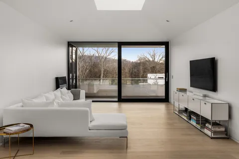 a living room with furniture a flat screen tv and a floor to ceiling window