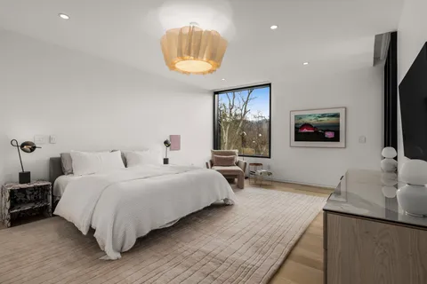 a bedroom with a bed and a large window