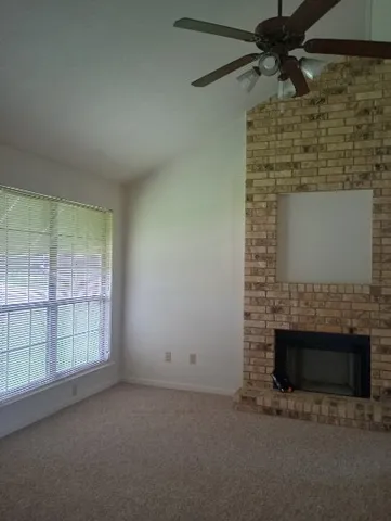 an empty room with windows and fireplace