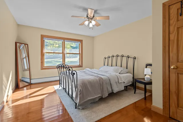 a bedroom with a bed and wooden floor