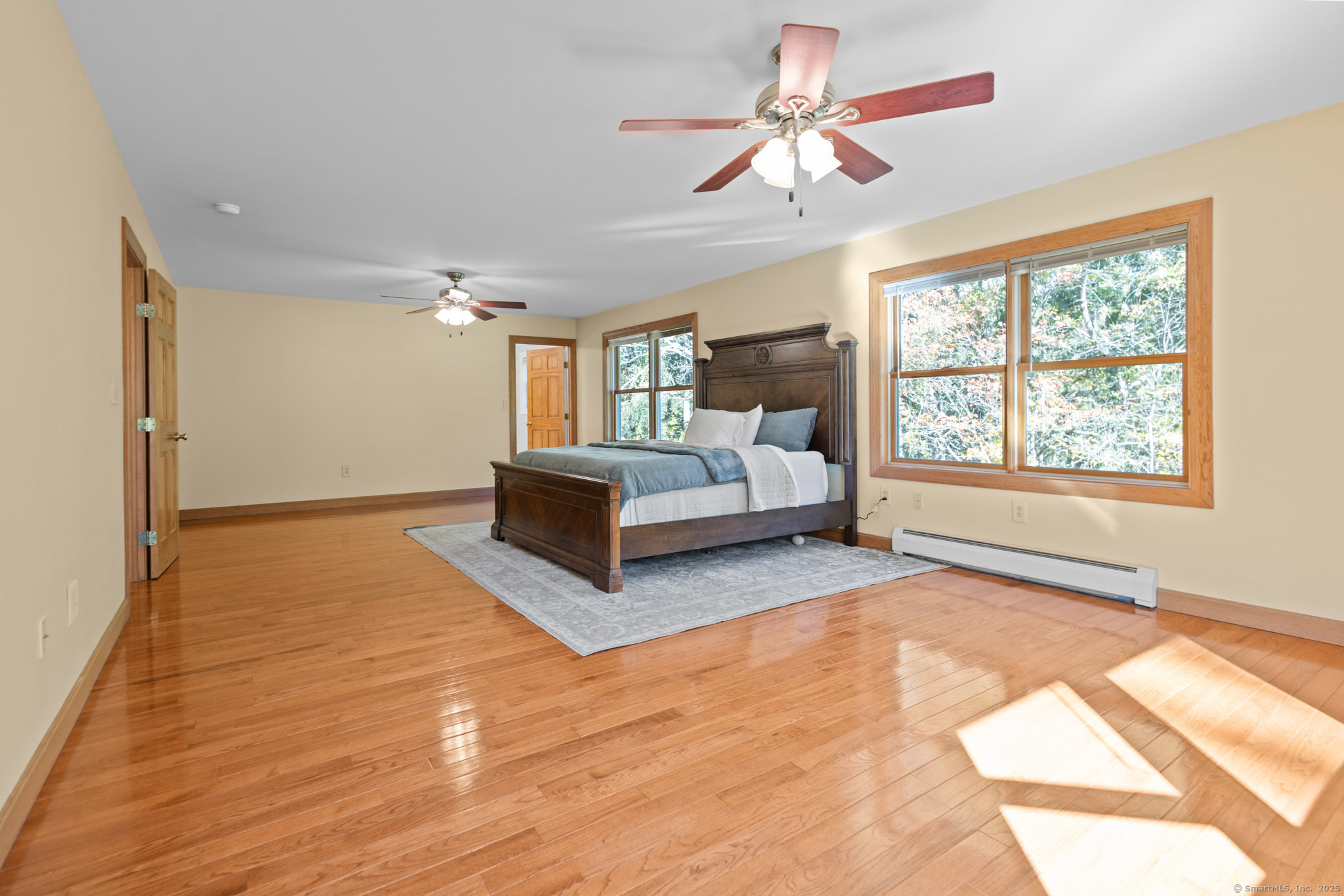 679 Bailey Hill Road Killingly, CT 06241 - Photo 26 of 39 a spacious bedroom with a large bed a chandelier and windows
