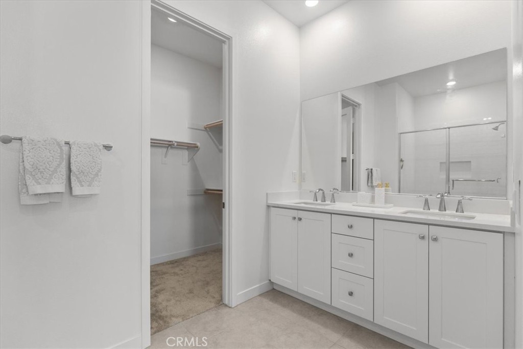 27410 Merlin Place, Unit 305 Valencia, CA 91381 - Photo 14 of 32 a bathroom with a double vanity sink and mirror