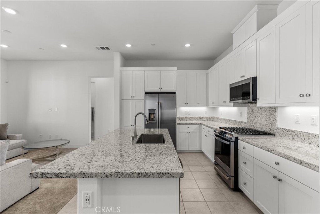 27410 Merlin Place, Unit 305 Valencia, CA 91381 - Photo 16 of 32 a kitchen with stainless steel appliances granite countertop a sink stove and refrigerator