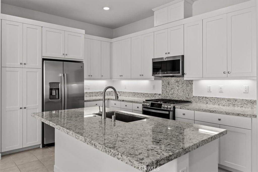 27410 Merlin Place, Unit 305 Valencia, CA 91381 - Photo 17 of 32 a kitchen with stainless steel appliances granite countertop a sink a stove and cabinets
