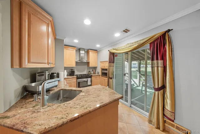 a kitchen with stainless steel appliances granite countertop sink stove refrigerator and cabinets