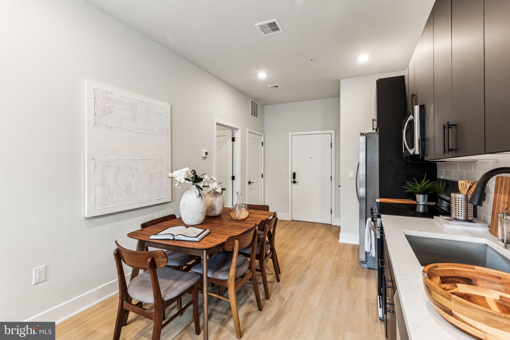 6910 Ridge Avenue, Unit 110 Philadelphia, PA 19128 - Photo 6 of 19 a view of a dining room with furniture a chandelier and wooden floor