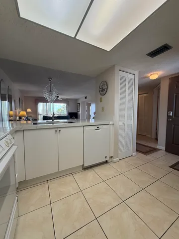 a kitchen with white cabinets a sink and white appliances