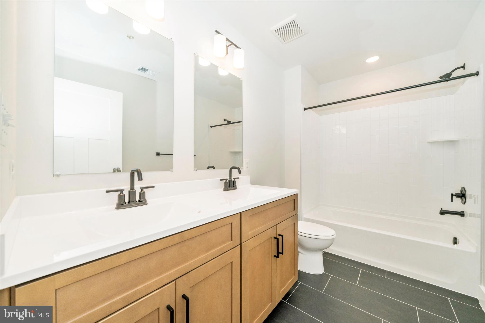 1156 Mt Zion Marlboro Road Lothian, MD 20711 - Photo 40 of 73 a bathroom with a sink a toilet a large mirror and shower