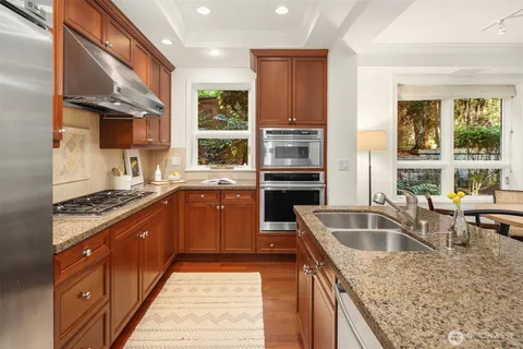 a kitchen with granite countertop a sink and a stove top oven