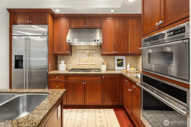 a kitchen with stainless steel appliances granite countertop a sink and a stove