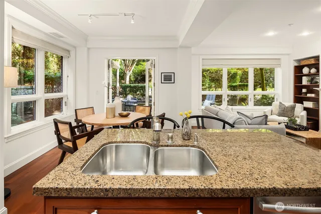 a kitchen with a granite countertop sink and wooden floor