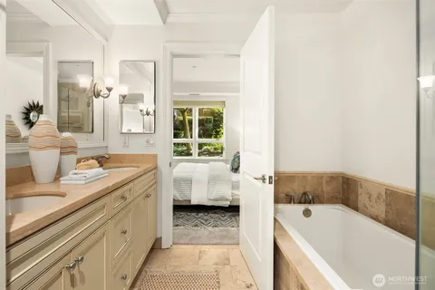 a bathroom with a tub sink and mirror