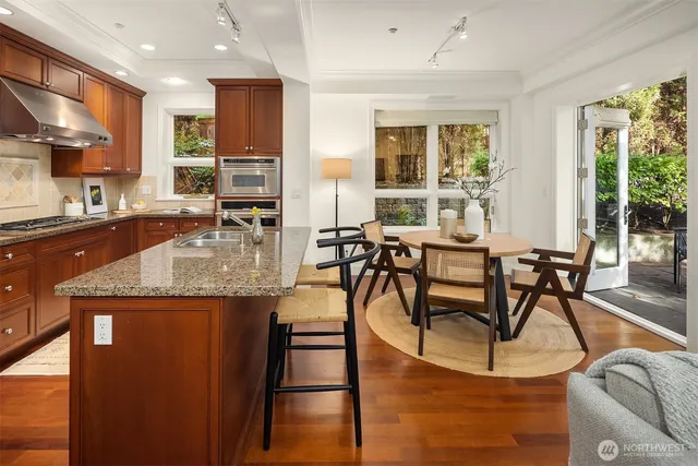 a kitchen with granite countertop a table chairs stove and granite counter top