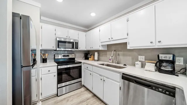 a kitchen with white cabinets sink and white appliances