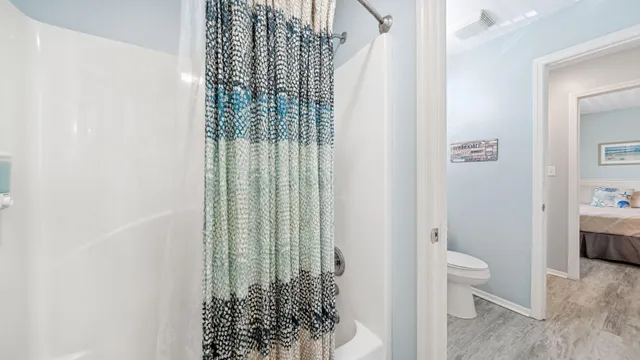 a bedroom with a bed and a flat tv screen on dresser