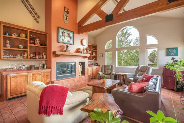 a living room with furniture fireplace and a large window