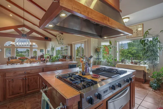 a kitchen with a stove and a view of living room