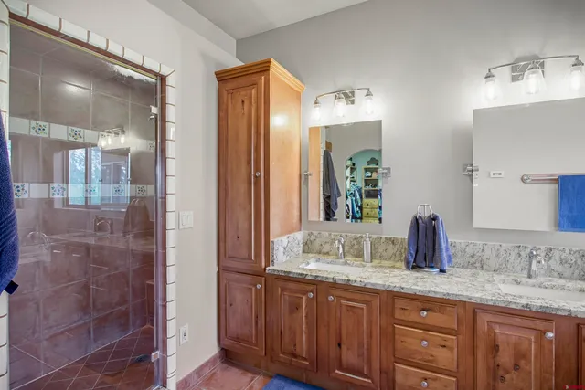 a bathroom with double sink and a mirror