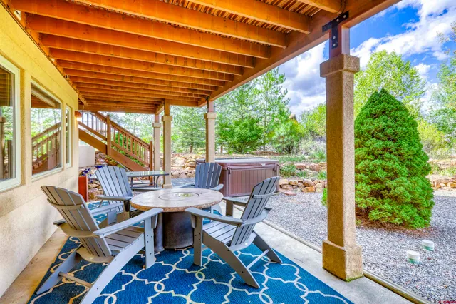a view of a patio with a table and chairs and couches with wooden floor