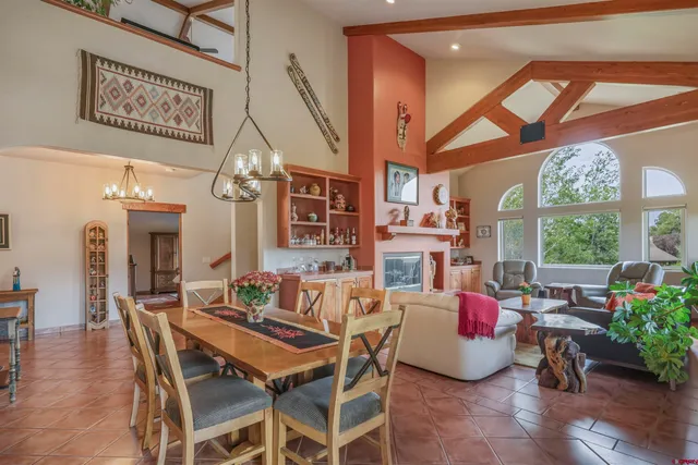 a dining room with furniture a chandelier and wooden floor